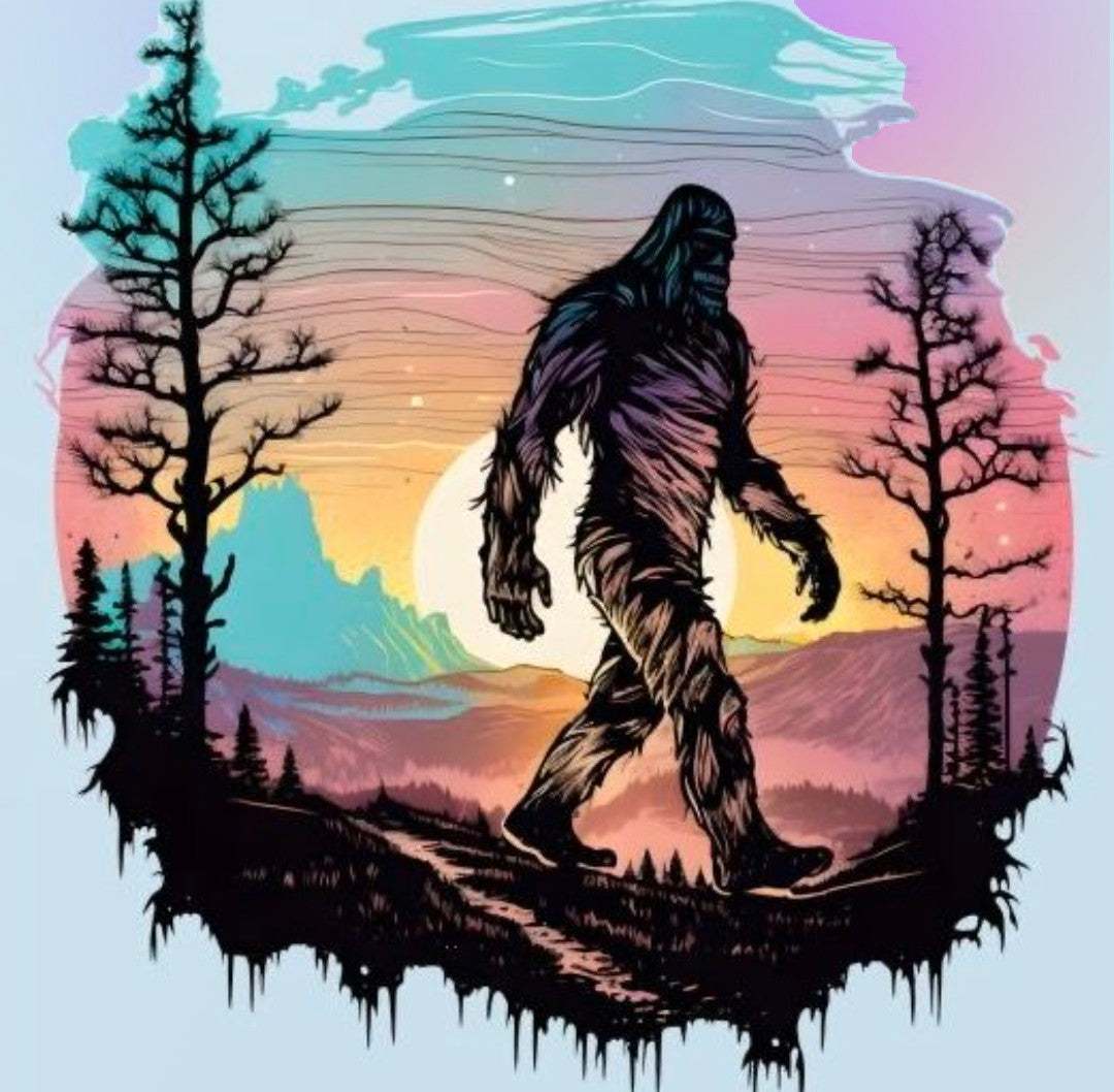 A wide banner for The Sassy Squatch Collection featuring a humorous Bigfoot graphic walking through a dense Idaho pine forest.