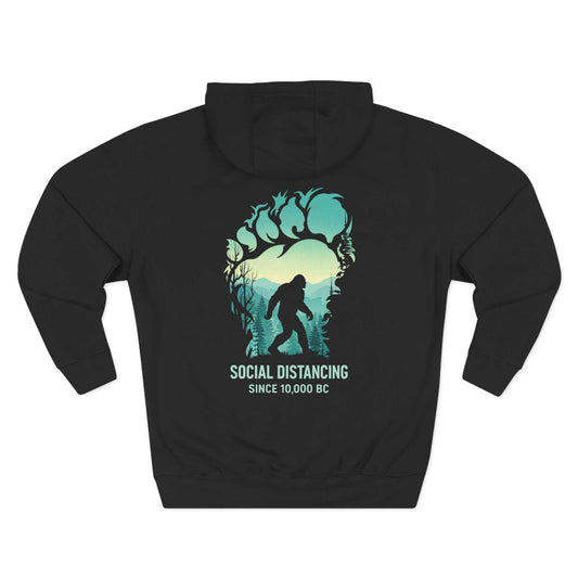 "The Bigfoot Social Distancing Hoodie in a cozy fleece pullover style, featuring a silhouette of Sasquatch and the text 'Social Distancing Since 10,000 BC'."