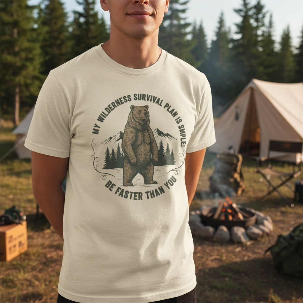 "A man wearing a Camp & Comfort wilderness survival plan tee while standing near a campfire in a pine forest."